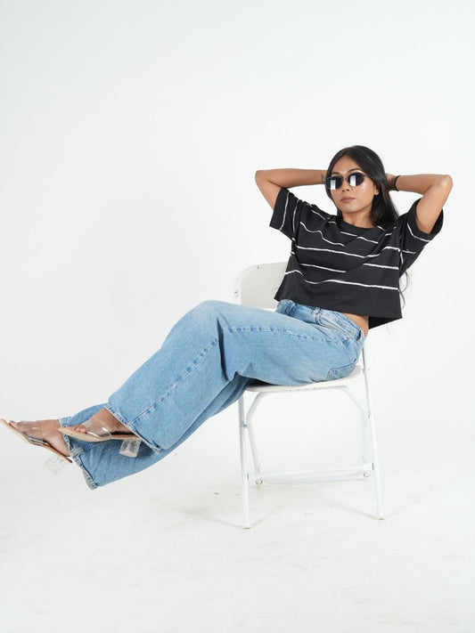 Stylish woman wearing a Black Artistic Crop Top Oversized T-shirt with jeans, perfect for casual looks this April.